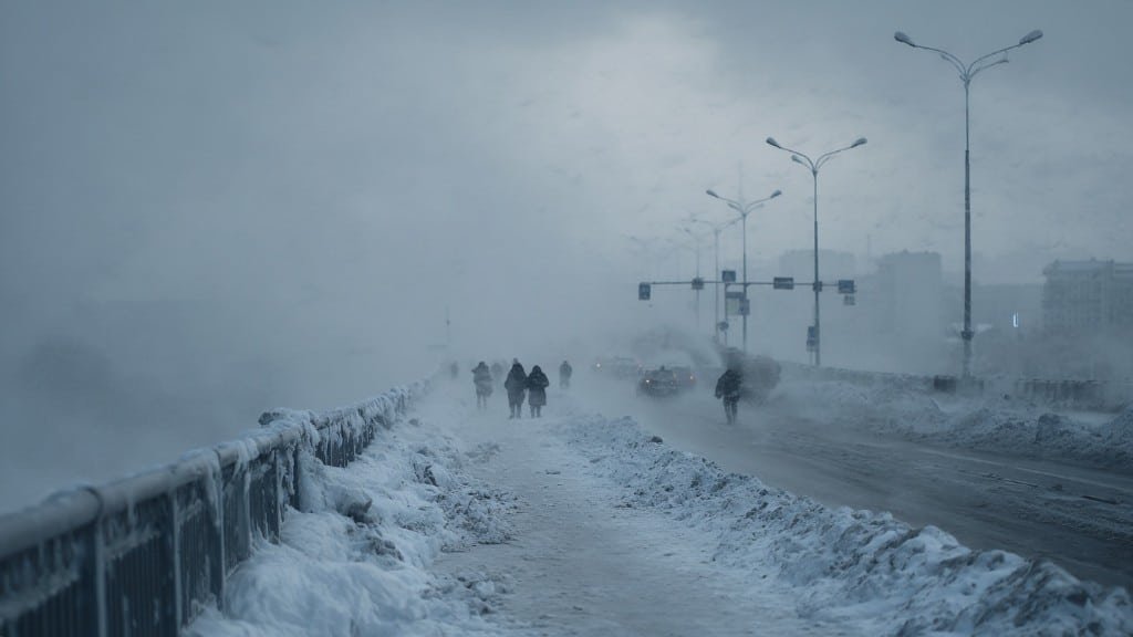 Пешеходы на мосту в Киеве в зимний ветреный день