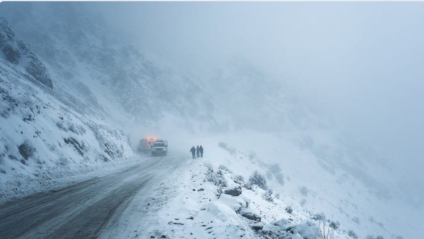 Горная дорога Кыргызстана, занесённая снегом, с застрявшим автомобилем