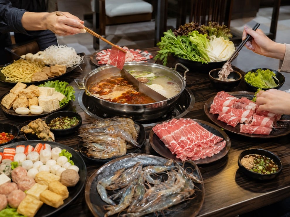 Organized all-you-can-eat hot pot table in Wichita with meat, seafood, vegetables, tofu, noodles and dipping sauces