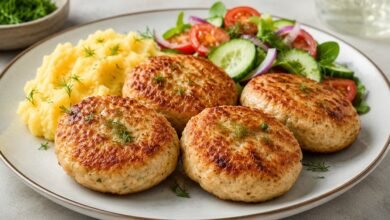Russian-style chicken kotleti served with mashed potatoes and fresh cucumber tomato salad