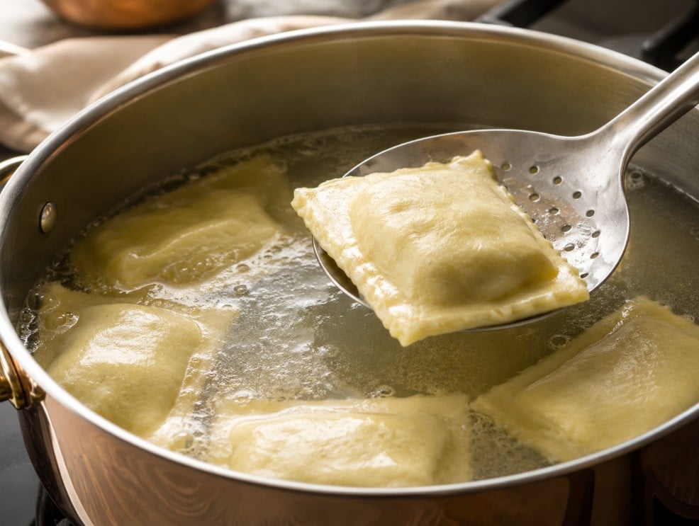 Frozen Maultaschen gently simmering in a wide pot with intact seams and controlled bubbles