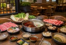 Hot pot in Wichita, Kansas with divided broth, sliced beef, seafood, tofu, mushrooms, greens, noodles, and dipping sauces
