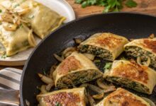 Sliced cooked Maultaschen pan-fried with golden onions and moist meat and spinach filling