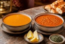 Mercimek çorbası and ezogelin soup served side by side with lemon, dried mint and Turkish bread