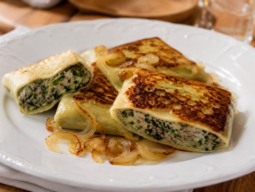 Pan-fried Maultaschen with browned surfaces, golden onions and moist visible filling