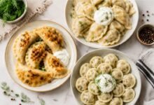 Pierogi versus varenyky versus pelmeni with fried onions, sour cream and fresh dill