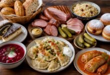 Polish food spread with pierogi, kielbasa, stuffed cabbage, beet soup, pickles, bread and pastries