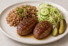 How to Order Russian Kotleti at a Restaurant, Deli or Market 4 Russian kotleti with mashed potatoes, cabbage and cucumber salad, pickles and gravy, with one cut open to show the ground-meat filling