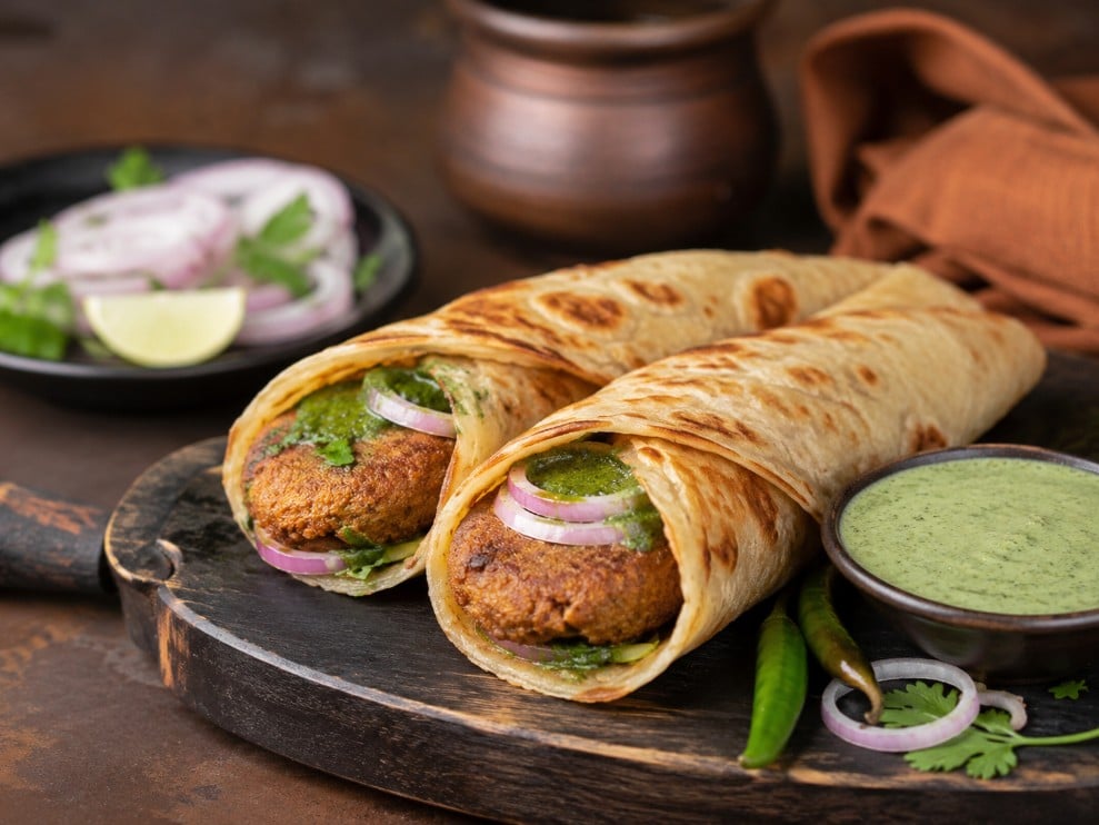 Shami kebab served in a bun and with paratha