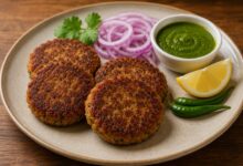 Shami kebab served with green chutney, red onion, lemon and green chilies